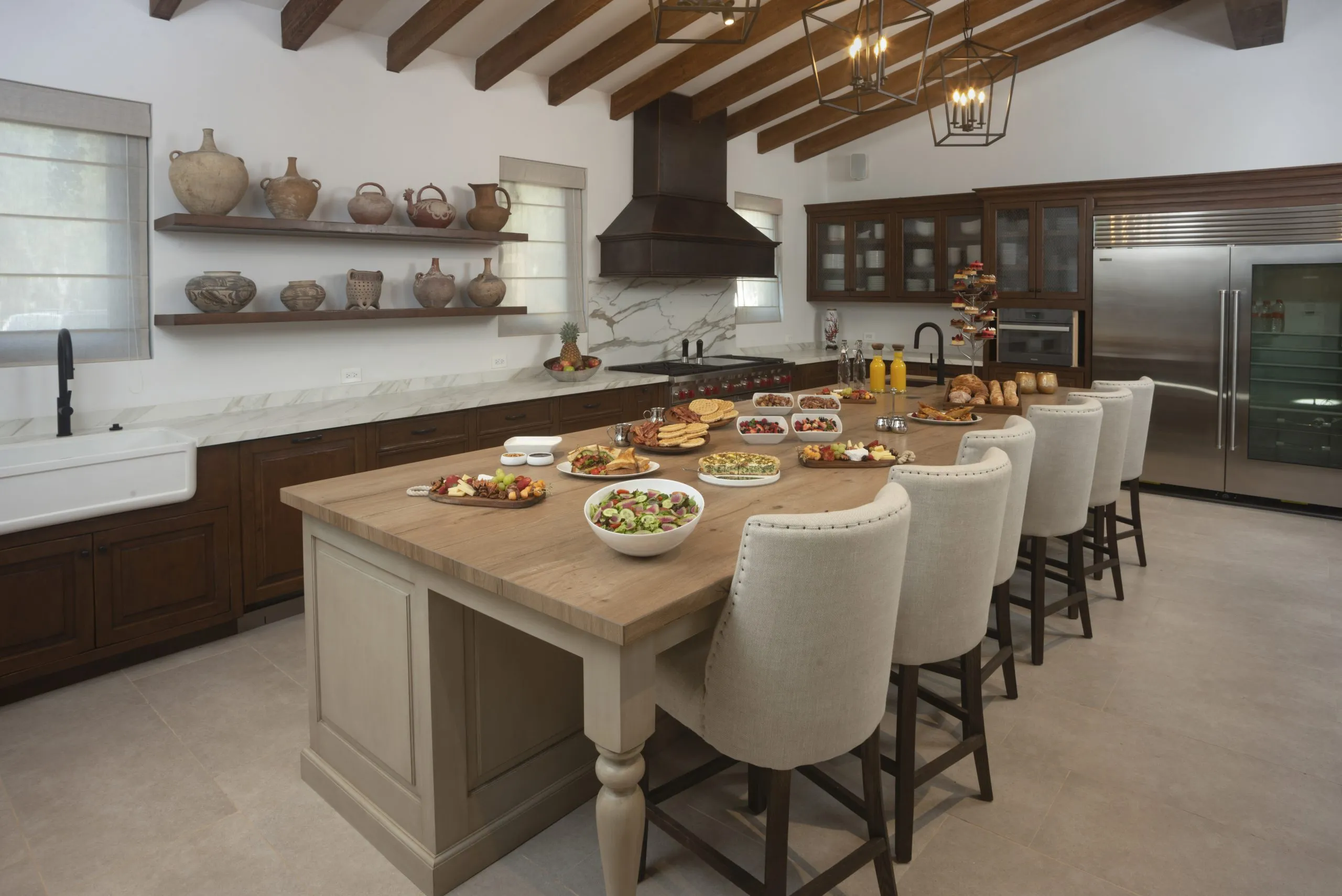 hay muchas sillas alrededor de la isla de la cocina con comida en ella