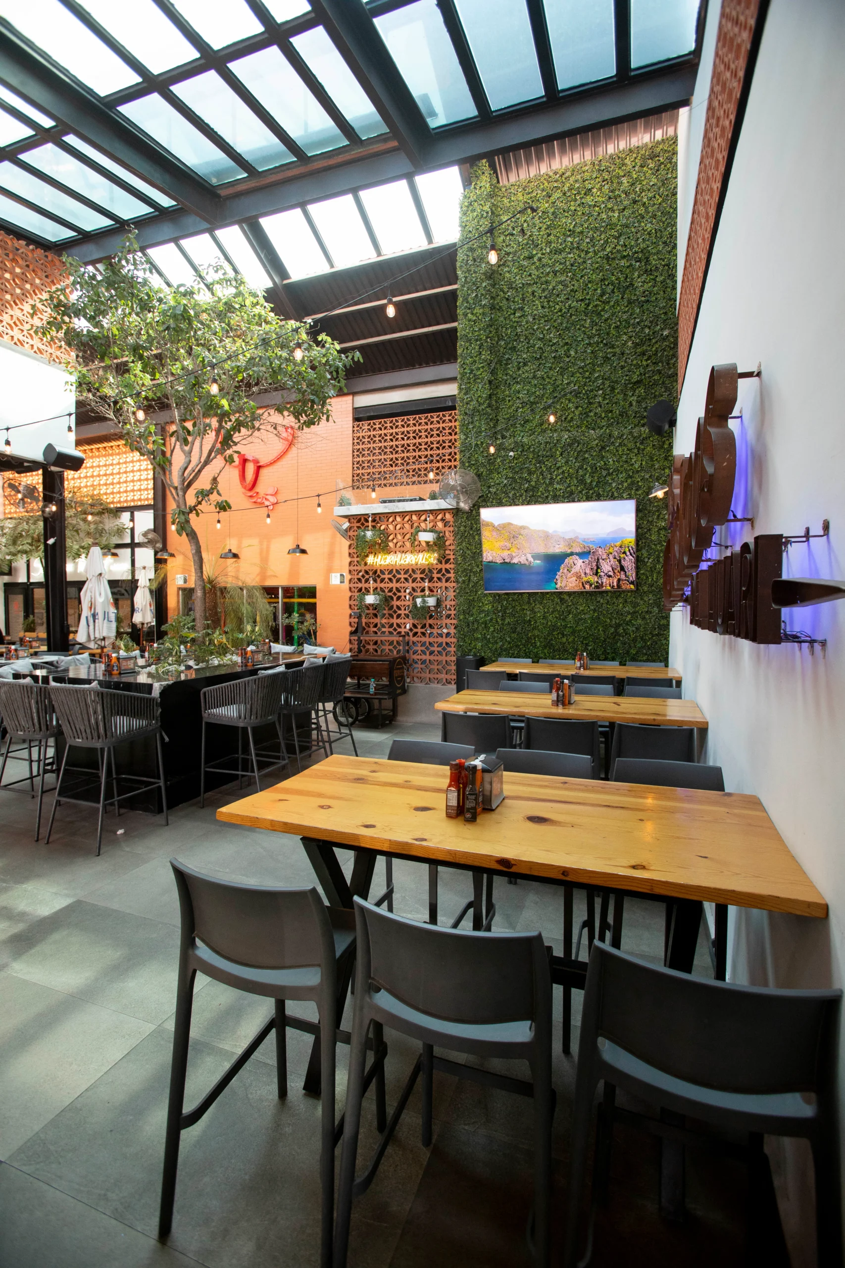 mesas y sillas en un restaurante con un tragaluz encima de ellos