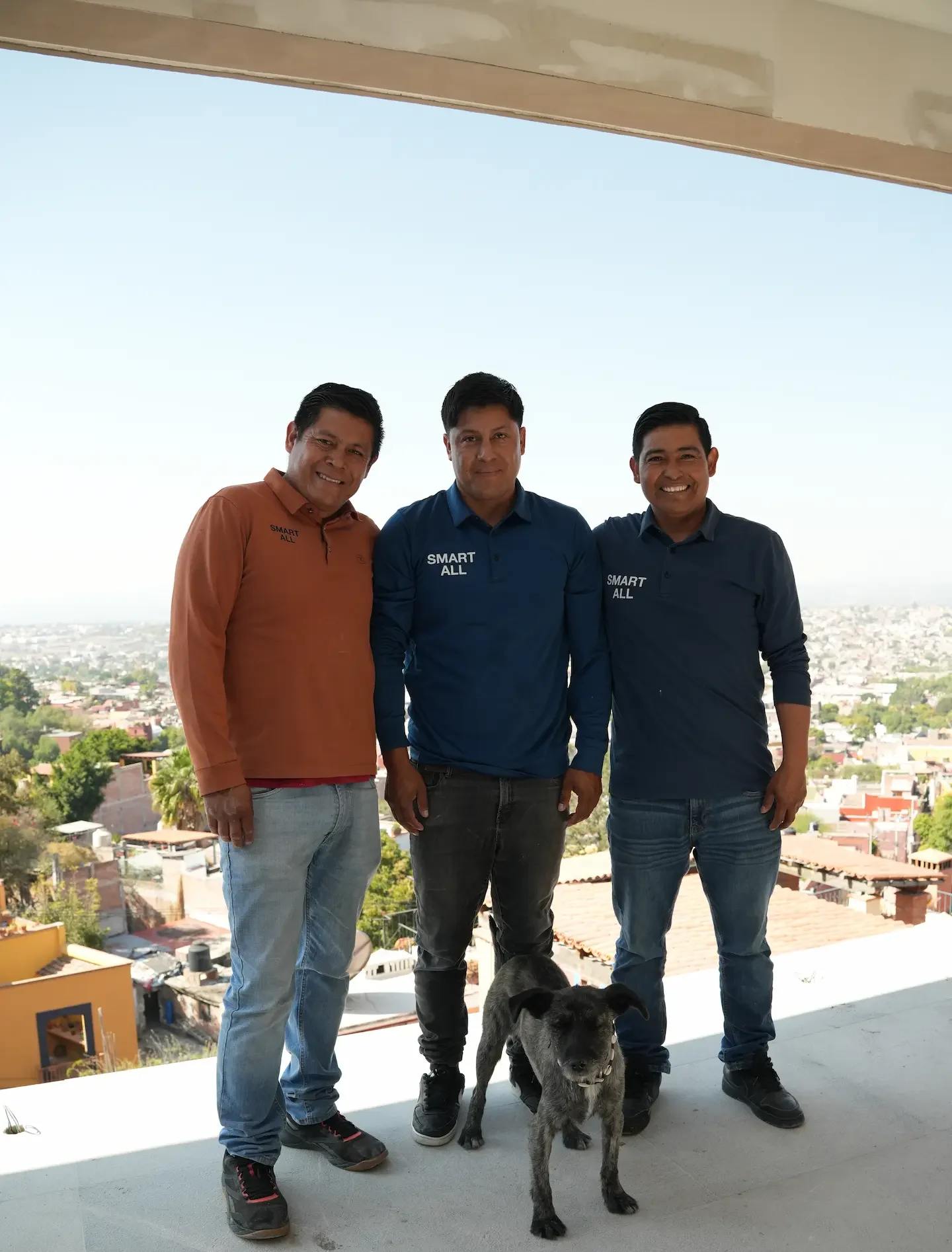 tres hombres de pie junto a un perro